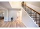 Bright foyer featuring hardwood floors, a staircase with decorative iron railings, and a view into the dining room at 10715 Glenbarr Dr, Johns Creek, GA 30097