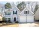 Charming two-story home featuring a two-car garage, well-manicured lawn, and classic architectural details at 10715 Glenbarr Dr, Johns Creek, GA 30097