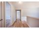 Hallway with light wood-look floors leading to other rooms, white trim, and neutral walls at 10715 Glenbarr Dr, Johns Creek, GA 30097