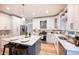 Modern kitchen featuring white cabinets, a center island with seating, and stainless steel appliances, offering both style and functionality at 10715 Glenbarr Dr, Johns Creek, GA 30097
