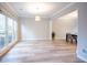 Bright living room featuring hardwood floors and large windows, flowing into a dining area with modern accents at 10715 Glenbarr Dr, Johns Creek, GA 30097