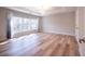 Spacious main bedroom with wood-look floors, large window, tray ceiling, and natural light at 10715 Glenbarr Dr, Johns Creek, GA 30097