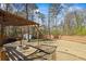 Spacious backyard featuring a fire pit under a pergola and a storage shed surrounded by a wood fence at 2130 Waters Ferry Dr, Lawrenceville, GA 30043