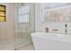 Bright bathroom featuring a modern soaking tub, sleek walk-in shower, and gold accents, complemented by natural light from the window at 2130 Waters Ferry Dr, Lawrenceville, GA 30043