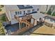 Aerial rear exterior featuring decks, covered patio, and landscaped backyard with fire pit at 2130 Waters Ferry Dr, Lawrenceville, GA 30043
