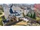 Aerial rear exterior featuring decks, covered patio, and landscaped backyard with fire pit and court at 2130 Waters Ferry Dr, Lawrenceville, GA 30043