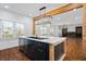 Kitchen island featuring a black sink and marble countertops, with an open view to the living room fireplace at 2130 Waters Ferry Dr, Lawrenceville, GA 30043