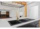 Kitchen island with black sink and marble countertops, with an open view to the living room fireplace at 2130 Waters Ferry Dr, Lawrenceville, GA 30043