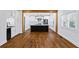 Spacious kitchen with hardwood floors, white walls, a black island, and an open floor plan to the dining area at 2130 Waters Ferry Dr, Lawrenceville, GA 30043