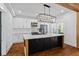 Modern kitchen featuring a large island with white marble countertop, black cabinets, and stylish lighting at 2130 Waters Ferry Dr, Lawrenceville, GA 30043