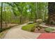 Driveway with brick trim, landscaped yard, and trees in a beautiful wooded setting at 2977 Glover Dr, Cumming, GA 30040