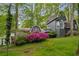 Charming home surrounded by lush greenery and vibrant azaleas, showcasing unique architectural details and curb appeal at 2977 Glover Dr, Cumming, GA 30040