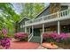 Charming home entrance with brick path, stone chimney and stairs leading to a covered porch with vibrant azaleas at 2977 Glover Dr, Cumming, GA 30040