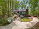 A charming home nestled among trees, with blooming azaleas adding pops of color to the landscaped front yard at 2977 Glover Dr, Cumming, GA 30040