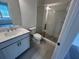 Modern bathroom with a glass-enclosed shower, white vanity, and tile floors at 623 Silva St # 130, Cumming, GA 30040