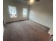 Empty bedroom with two windows and neutral carpeting awaiting customization to match the homeowner's style at 623 Silva St # 130, Cumming, GA 30040