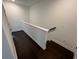 Hallway featuring dark hardwood floors and a white railing at 623 Silva St # 130, Cumming, GA 30040