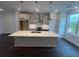 Bright open kitchen featuring stainless steel appliances, a large island, and dark wood flooring at 623 Silva St # 130, Cumming, GA 30040