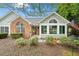 Inviting single-Gathering home showcasing a brick facade, sunroom, and manicured landscaping at 12103 Windrush Ln, Alpharetta, GA 30009