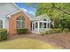 Well-kept single-Gathering home featuring a brick accent, sunroom, and lush front yard at 12103 Windrush Ln, Alpharetta, GA 30009