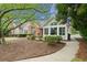 Charming single-Gathering home with a well-maintained lawn and a cozy sunroom addition at 12103 Windrush Ln, Alpharetta, GA 30009