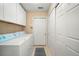 Well-equipped laundry room with side by side washer and dryer, ample storage space, and easy access to the rest of the house at 12103 Windrush Ln, Alpharetta, GA 30009