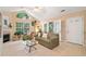Cozy living room with vaulted ceilings, fireplace, and abundant natural light from large windows at 12103 Windrush Ln, Alpharetta, GA 30009