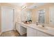 Bathroom featuring double sinks, white cabinetry, large mirrors, and a walk-in shower at 12103 Windrush Ln, Alpharetta, GA 30009