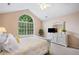 Bright main bedroom with a large window, ceiling fan, and a white dresser with a mirror at 12103 Windrush Ln, Alpharetta, GA 30009