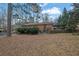 View of the backyard and the back of the house, which features brick siding and a covered area at 4222 Webb Rd, Tucker, GA 30084