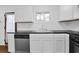 This kitchen has stainless steel appliances, black counters, white cabinets, and hardwood flooring at 4222 Webb Rd, Tucker, GA 30084