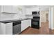 Well-lit kitchen featuring white cabinets, black appliances, and a view of the backyard at 4222 Webb Rd, Tucker, GA 30084