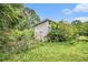 View of the rear of the home surrounded by mature trees and natural landscape, with a partial view of a side yard at 8600 Andy Mountain Ct, Villa Rica, GA 30180