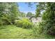 Backyard shot showcasing the house and surrounding trees and green foliage, creating a private setting at 8600 Andy Mountain Ct, Villa Rica, GA 30180