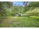 Exterior shot of storage shed with large doors, nestled in a lush green backyard with surrounding trees at 8600 Andy Mountain Ct, Villa Rica, GA 30180