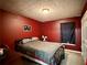 Bedroom with a metal frame bed, red walls, and a patterned ceiling at 1902 Mack Rd, Douglasville, GA 30135
