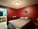 Cozy bedroom with red walls, carpet floor, double bed, and dark wood dresser at 1902 Mack Rd, Douglasville, GA 30135