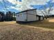 View of this two-story home's siding and foundation and its large lot and autumn-colored grass at 1902 Mack Rd, Douglasville, GA 30135