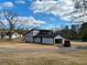 Two-story grey home with an attached garage and spacious driveway under a partly cloudy sky at 1902 Mack Rd, Douglasville, GA 30135