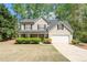 Charming two-story home with a well-maintained lawn, attached garage, and mature trees at 4315 Summit Heights Dr, Snellville, GA 30039
