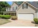 Close-up of a two-story house with an attached garage and meticulously maintained landscaping at 4315 Summit Heights Dr, Snellville, GA 30039