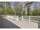 Spacious back deck with white railing offers lovely wooded views, a perfect outdoor retreat to enjoy nature's beauty at 2610 Crestdale Se Cir, Atlanta, GA 30316