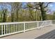 Wood deck with white railing providing a peaceful, private view of the surrounding trees and sky at 2610 Crestdale Se Cir, Atlanta, GA 30316