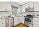A bright kitchen featuring stainless steel appliances, white cabinets, and granite countertops at 2610 Crestdale Se Cir, Atlanta, GA 30316