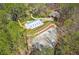 Aerial view of the property showcasing the main house, the barn with a metal roof and a dirt riding ring at 5388 Frazer Rd, Buford, GA 30518