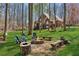 Outdoor fire pit with seating surrounded by mature trees and lush greenery at 5388 Frazer Rd, Buford, GA 30518