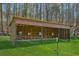 A spacious wooden barn structure with open sides, perfect for sheltering horses or livestock on the property at 5388 Frazer Rd, Buford, GA 30518