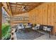 A comfortable, covered patio features wood walls, seating, rug, and ceiling fan at 5388 Frazer Rd, Buford, GA 30518