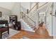 Welcoming foyer with staircase, hardwood floors, and view into other living spaces at 5388 Frazer Rd, Buford, GA 30518