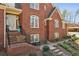 Charming brick home's front entrance with steps, ornate door, and blossoming landscaping at 5388 Frazer Rd, Buford, GA 30518